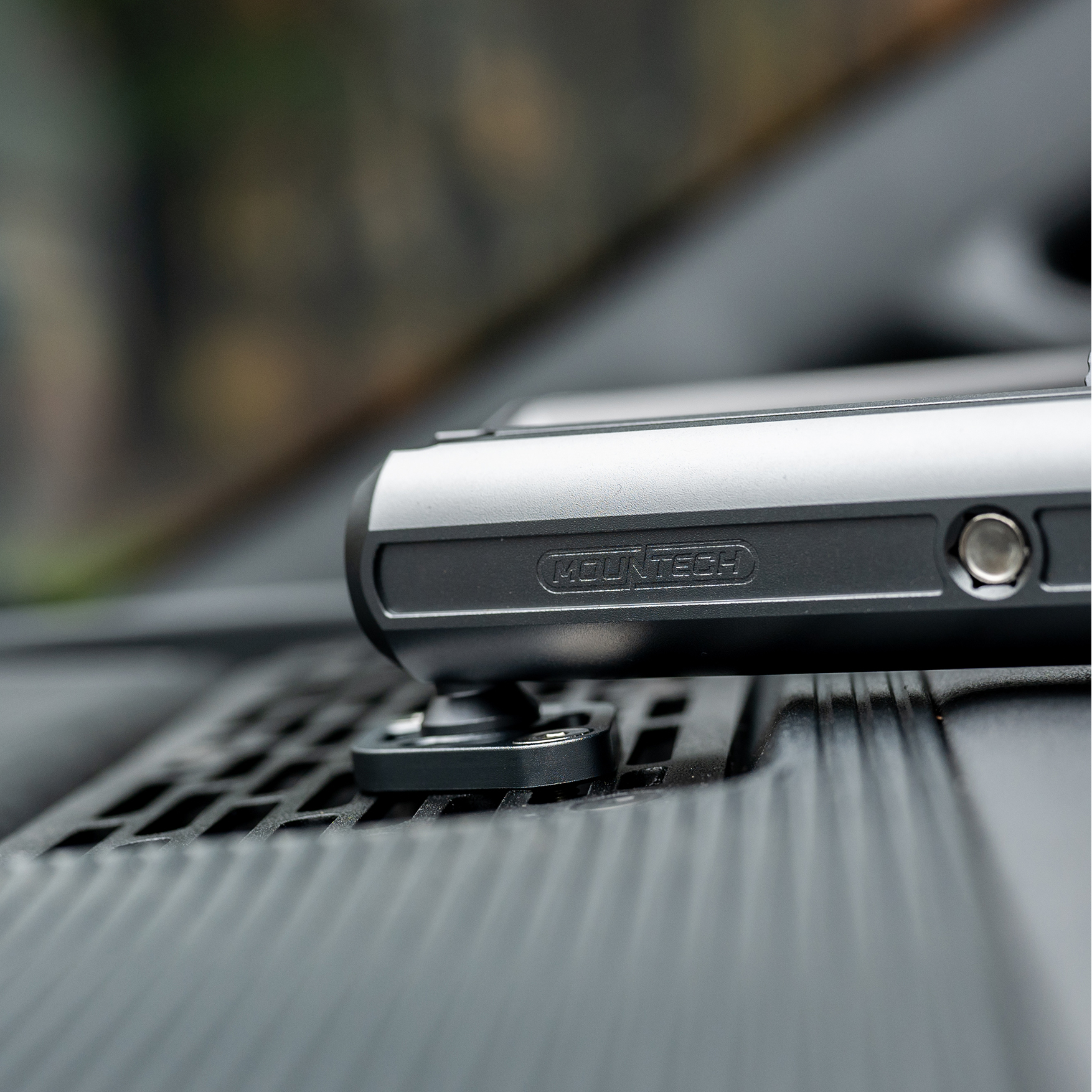 Phone holder on a car dashboard with Mountech branding.